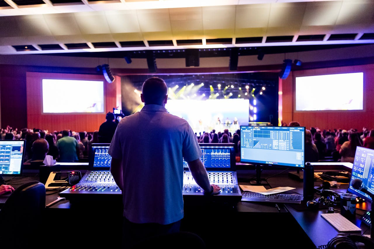 Sound engineer managing control desk during a live music event in an indoor venue.